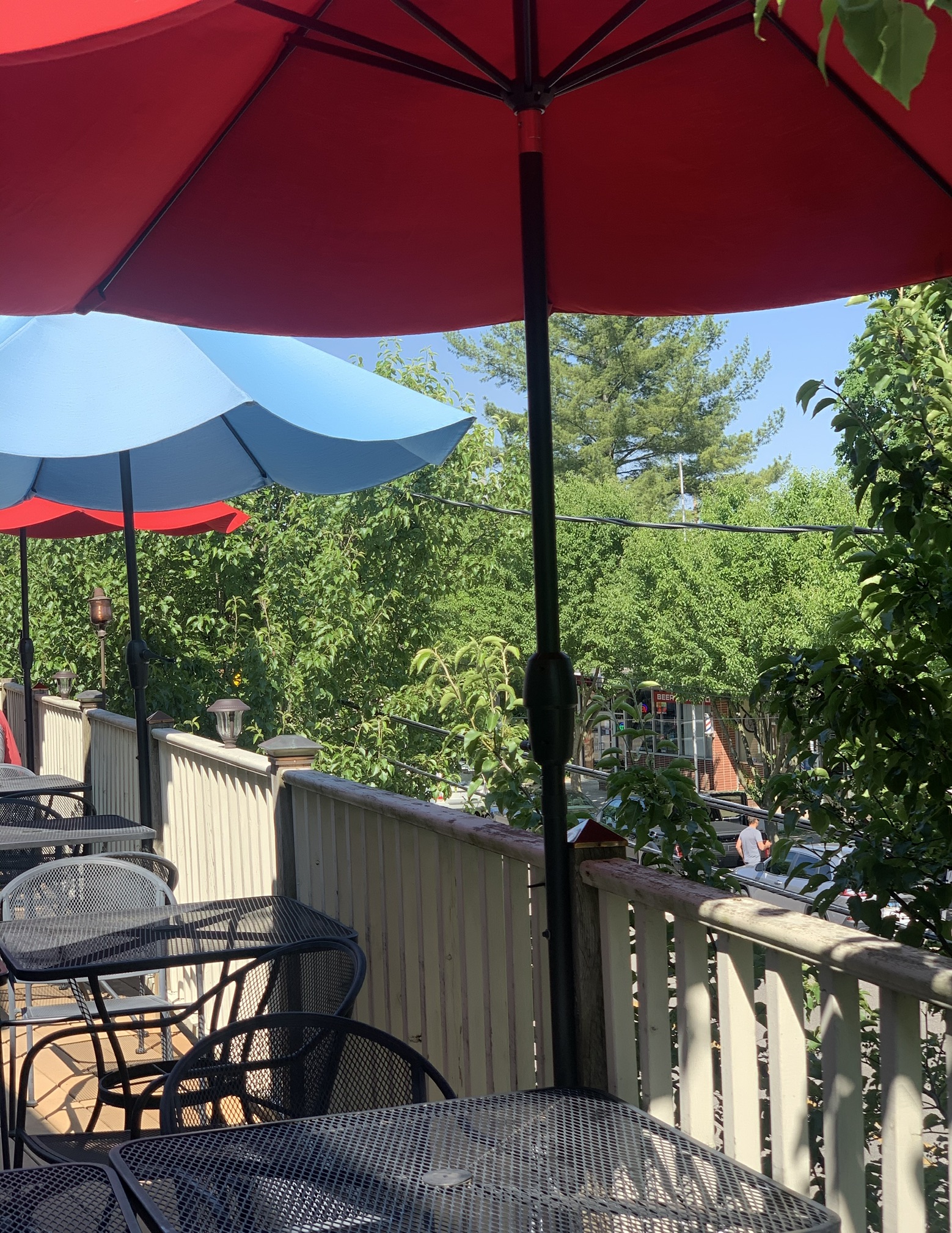 The rooftop deck by day, under red and blue umbrellas