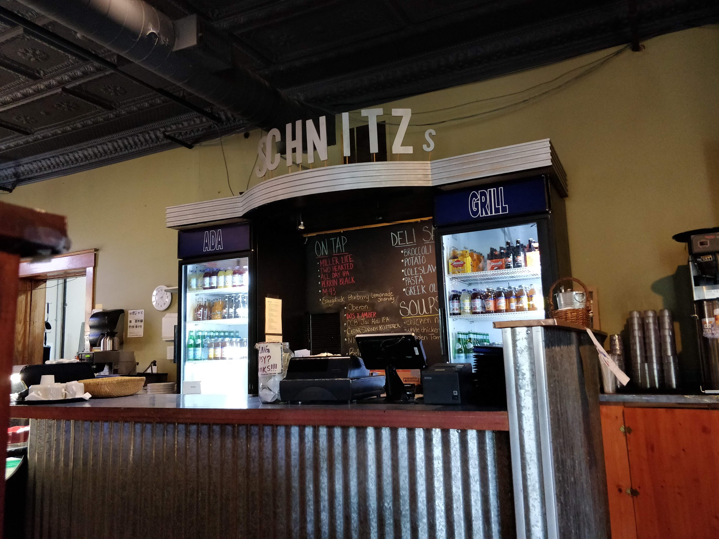 The Schnitz deli counter — corrugated steel front, chalkboard menus and the SCHNITZ sign overhead