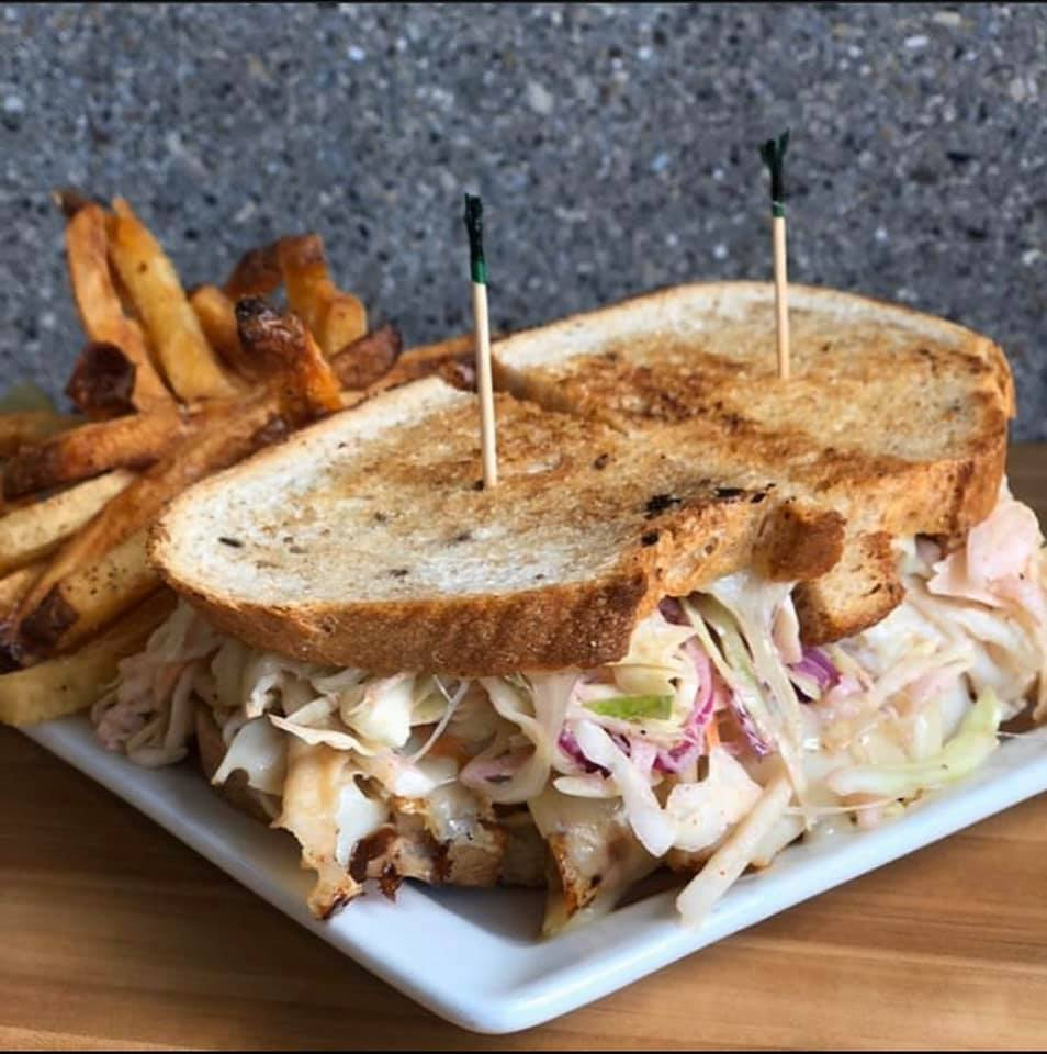 Toasted melt with slaw and hand-cut fries on a white plate